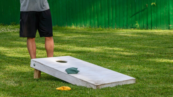 playing-corn-hole-bags-game-in-backyard